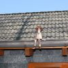 Dachrinnenfigur Mann sitzend auf Dachrinne