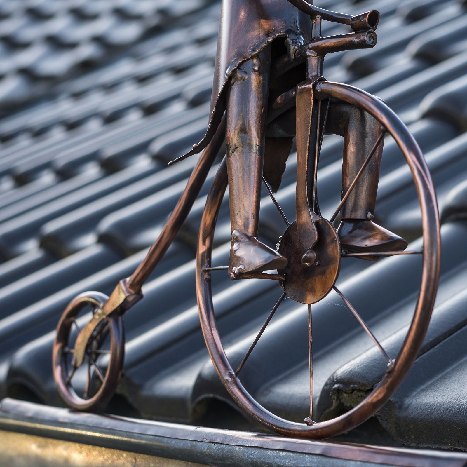 Koperen figuur voor de goot, penny-farthing ruiter, historische fiets