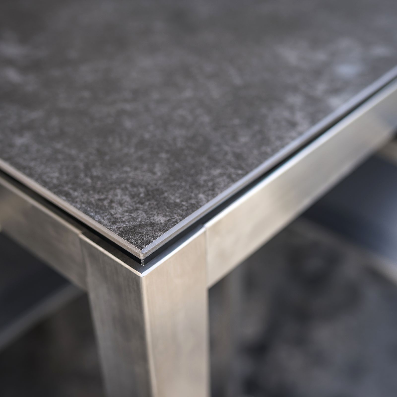 Tavolo da esterno in acciaio inox con piano in vetroceramica, design angolare